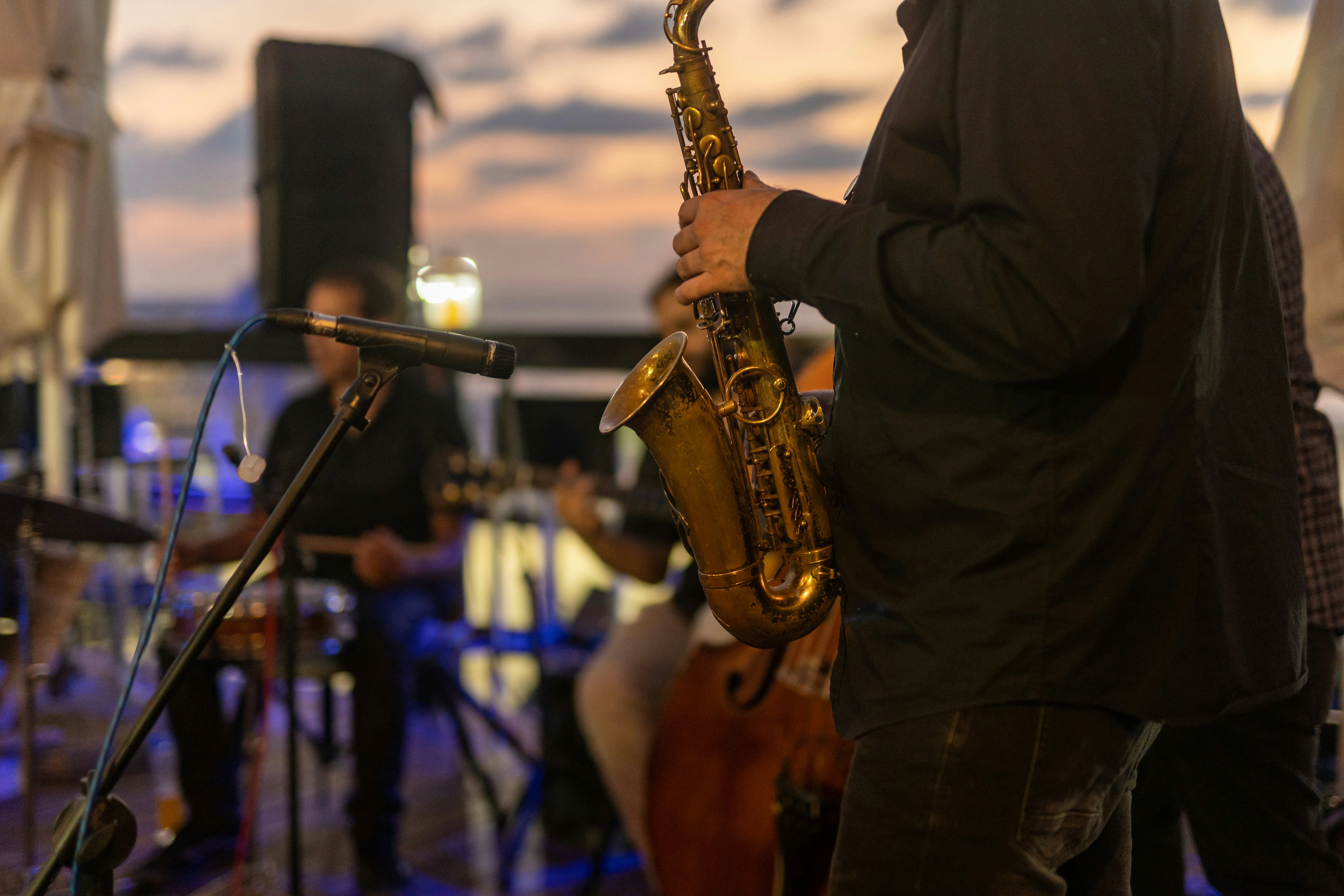 Man met saxofoon op een podium in de buitenlucht