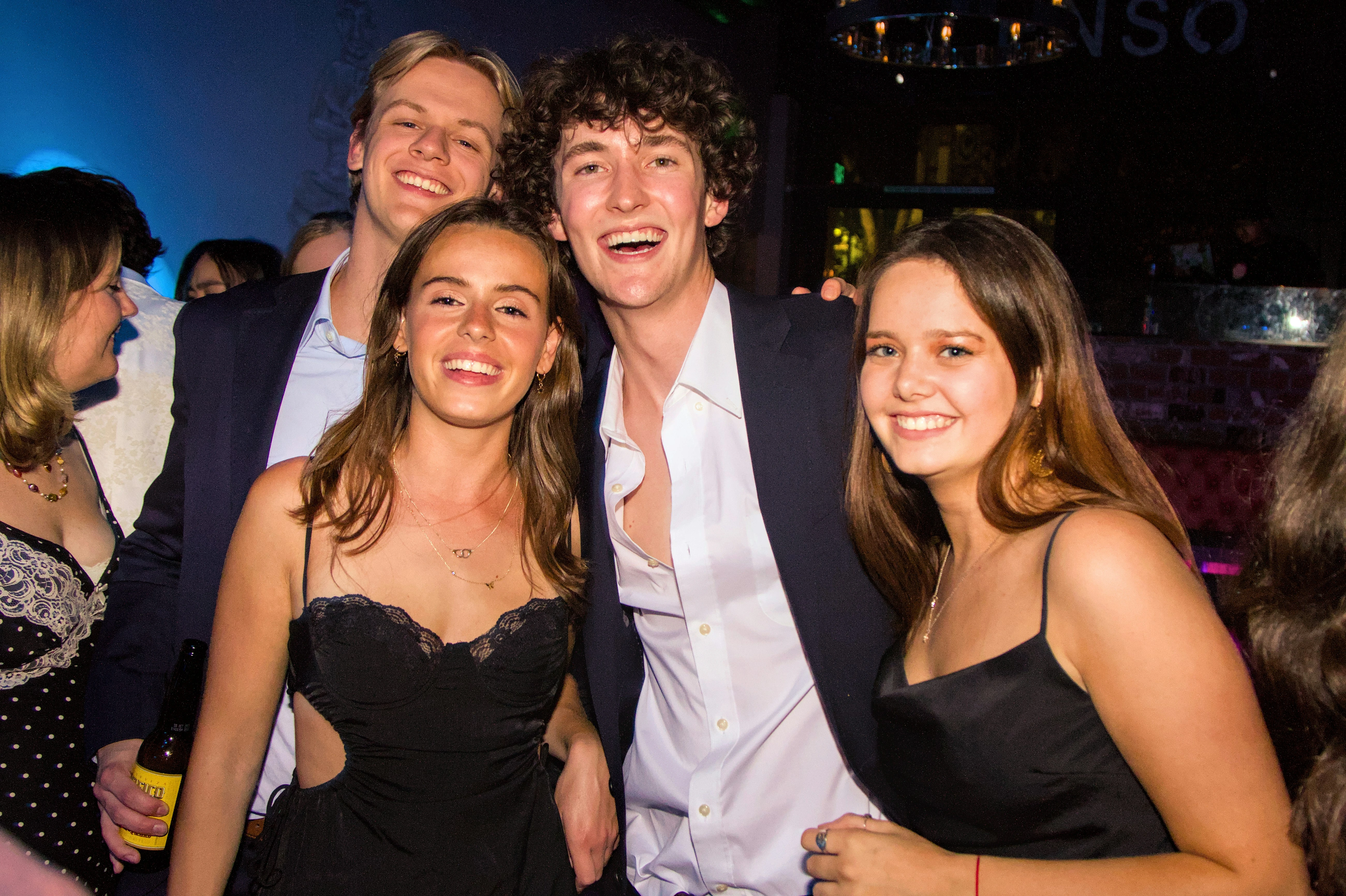 Groep jong volwassenen poseert lachend tijdens gala-avond