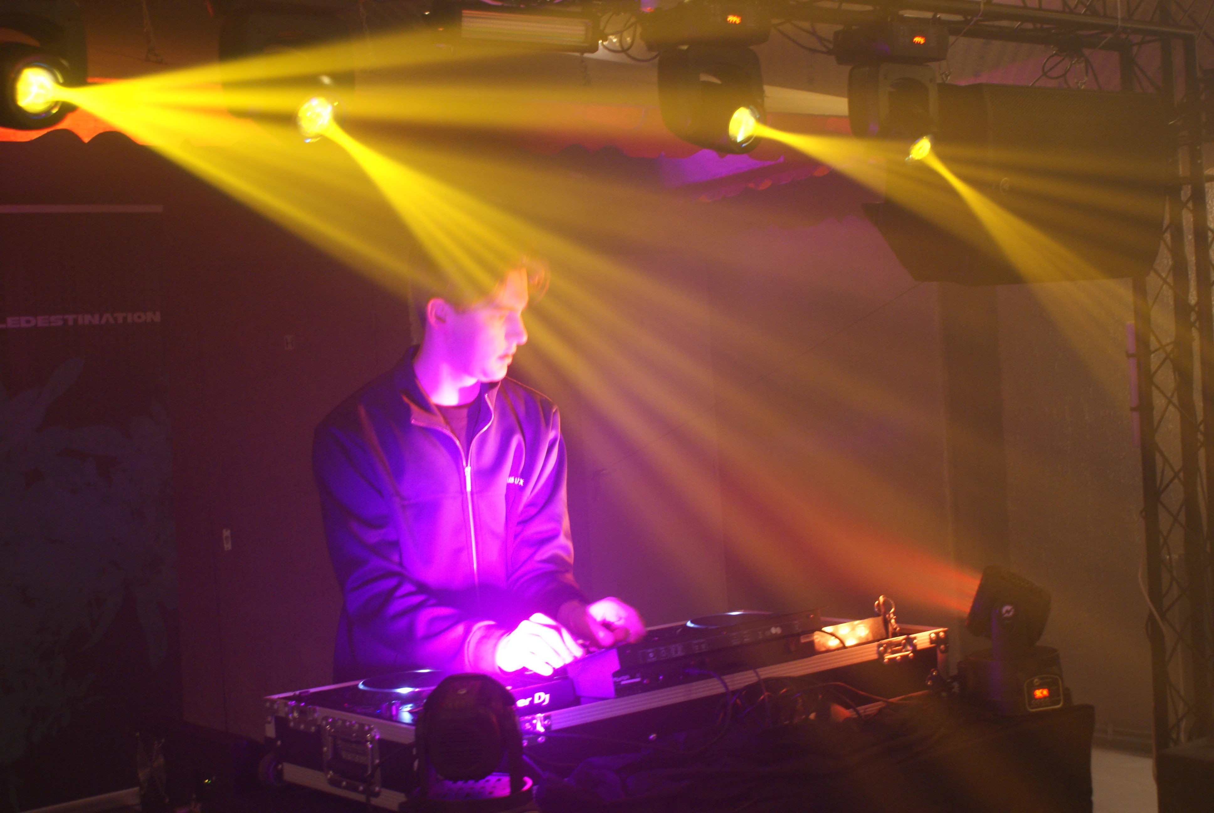 DJ-setup op housewarming feest met gele en paarse lichtstralen en rook