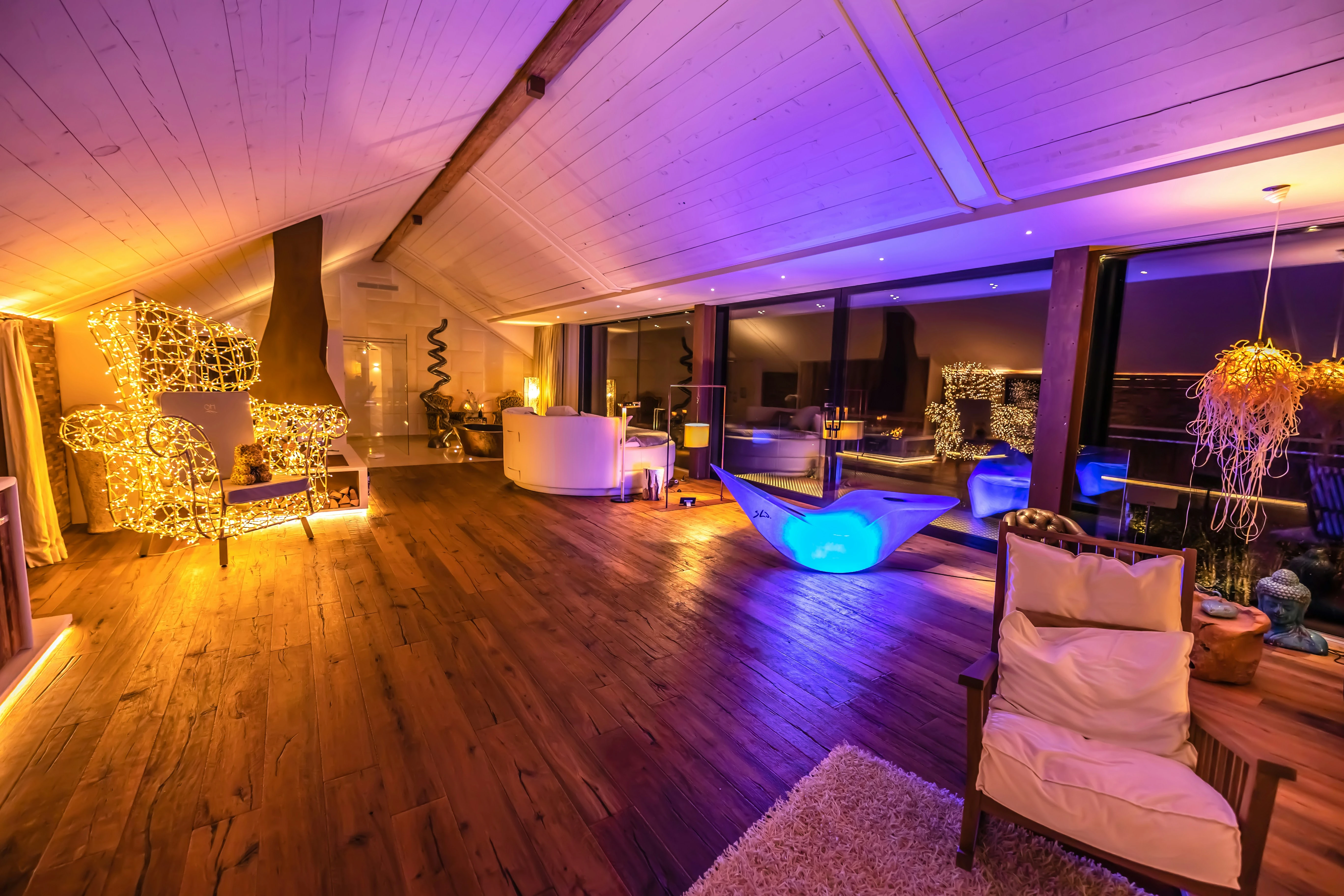 Woonkamer op housewarming feest met blauwe en paarse sfeerverlichting en houtenvloer