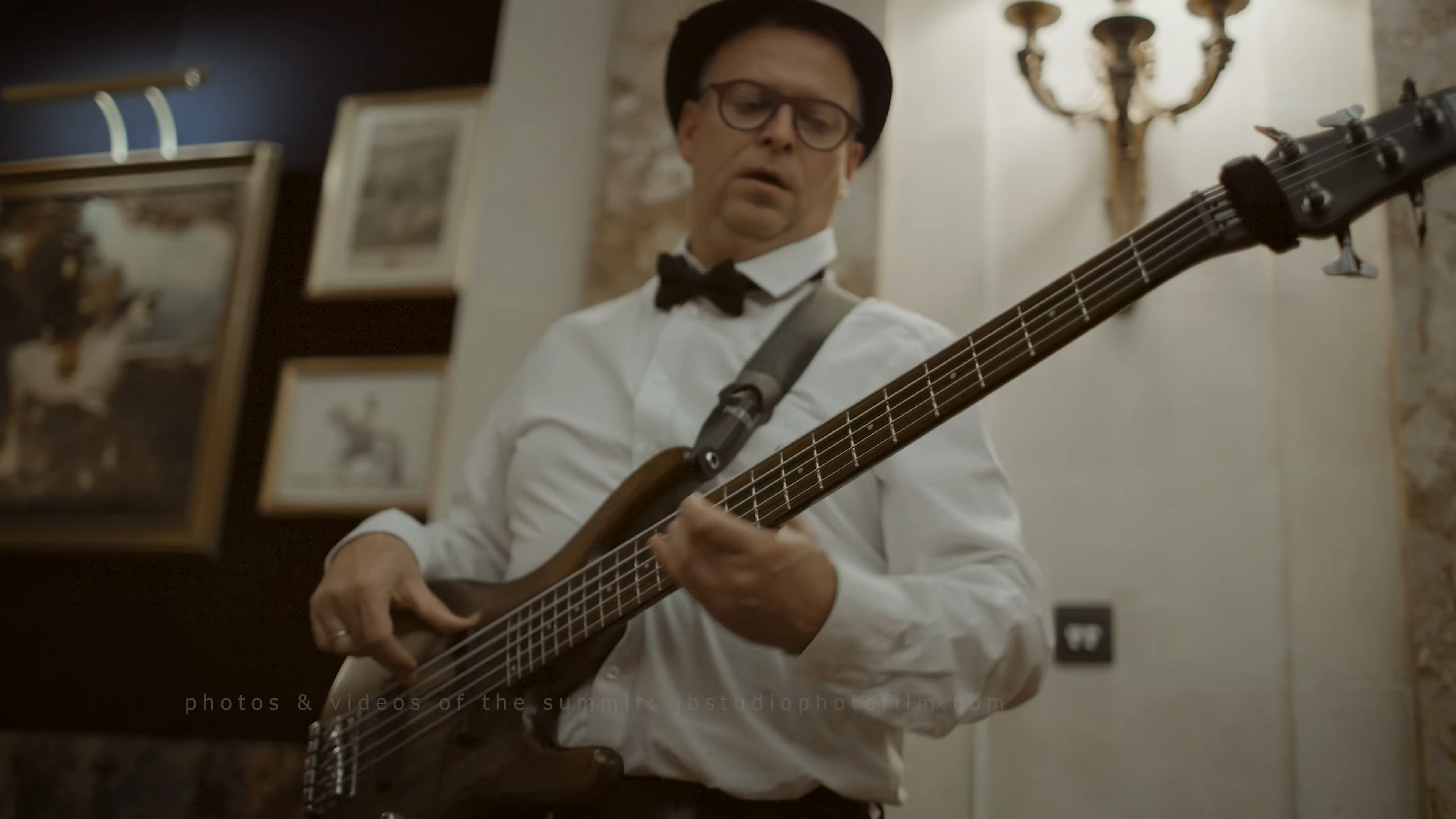 Muzikant in formele kleding speelt basgitaar op kerstborrel