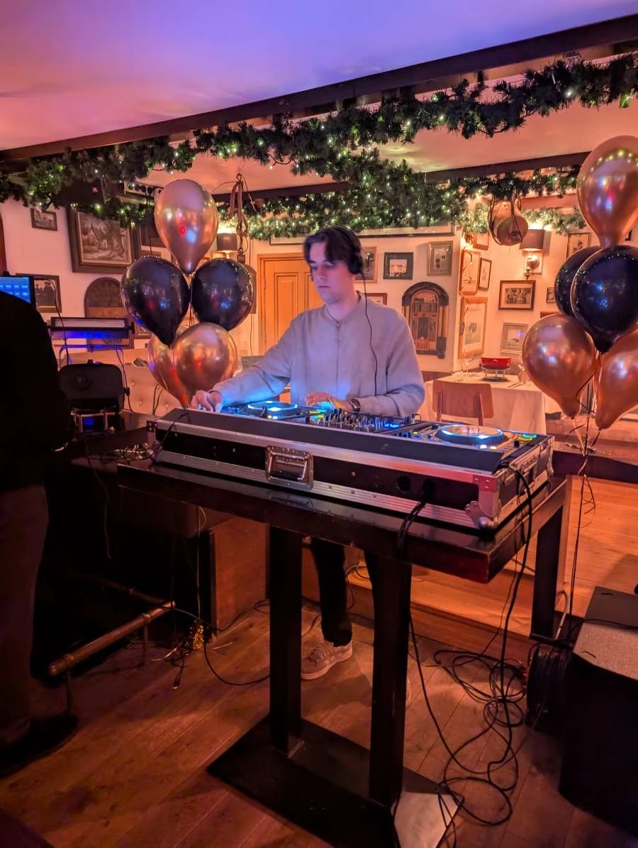Muzikant in formele kleding speelt basgitaar op kerstborrel