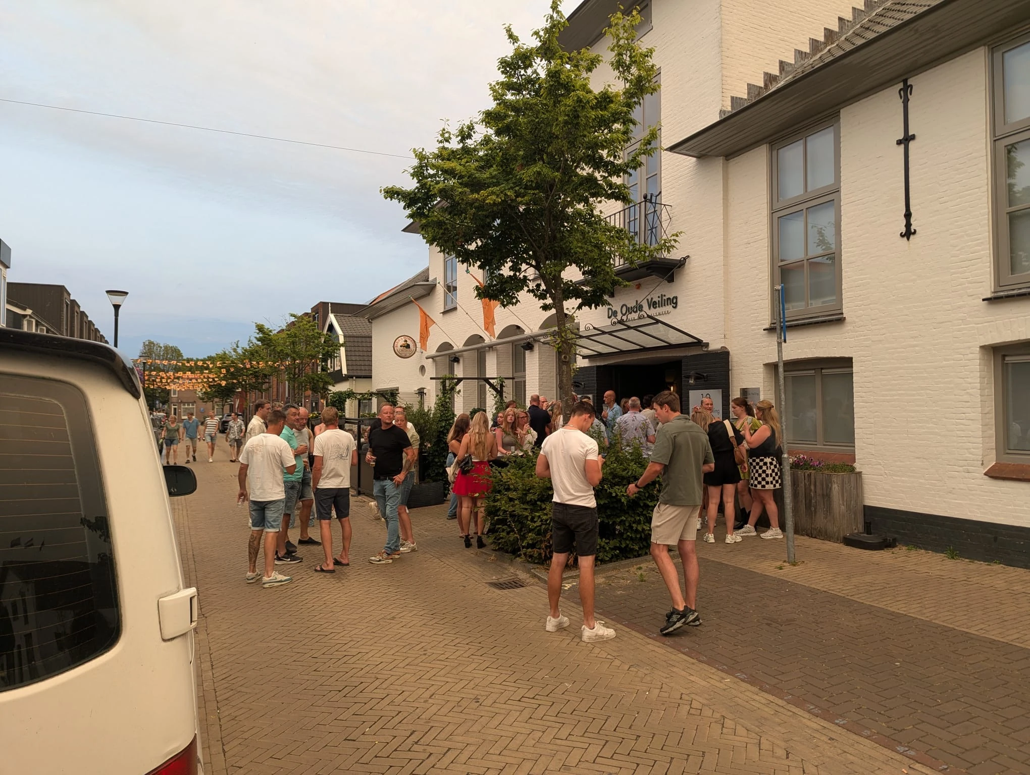 Guests gather outside at customer appreciation day on street between buildings