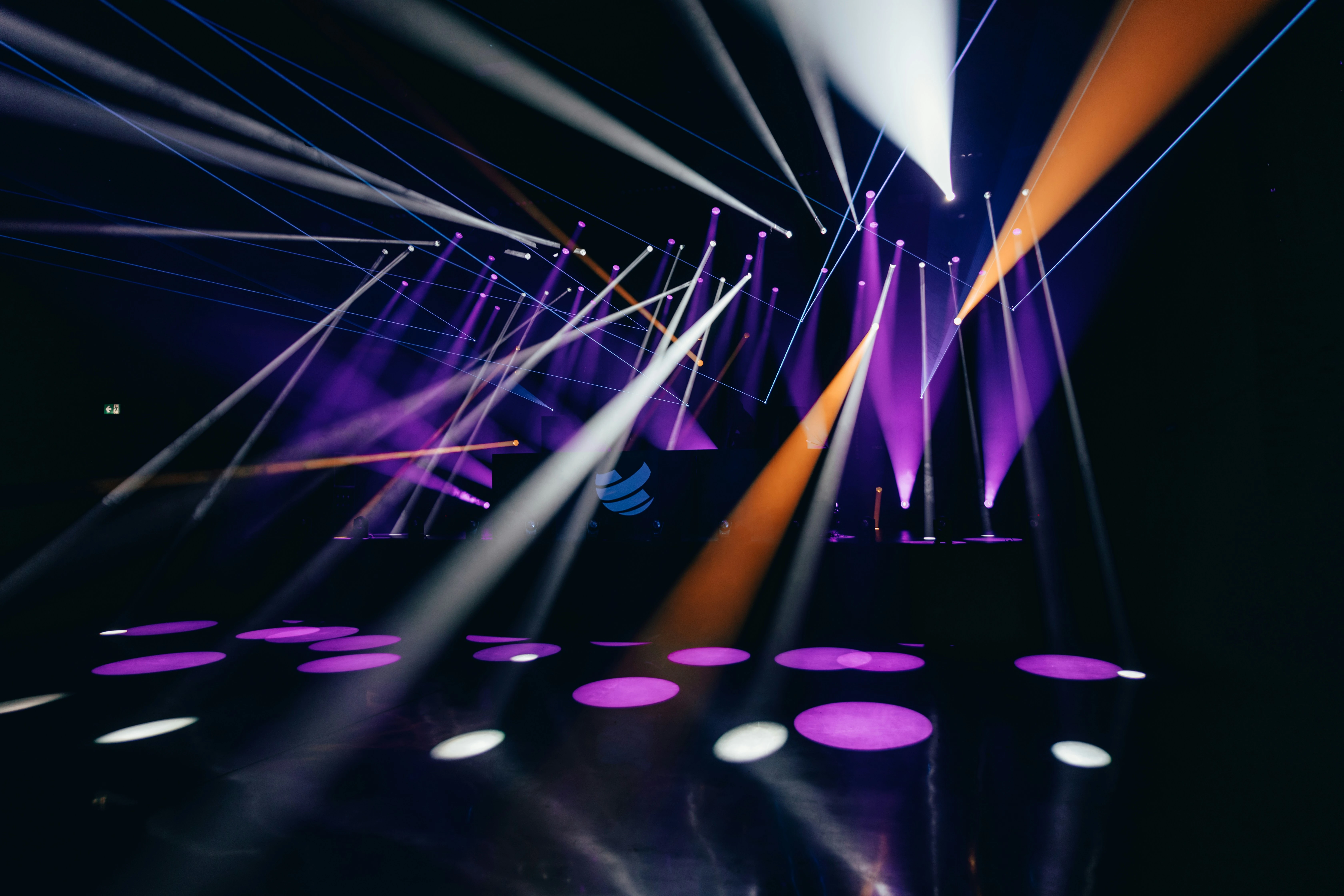 Podium op productlancering met paarse en oranje lichtstralen en dansvloer