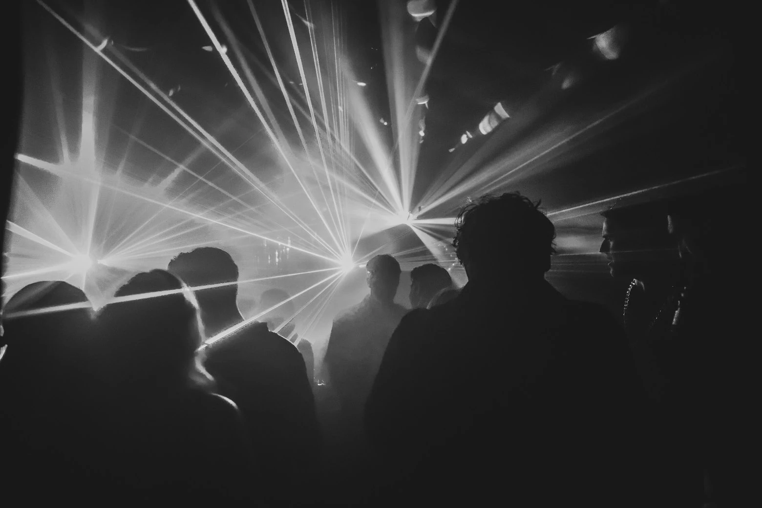 Zwartwit afbeelding van lasers door publiek