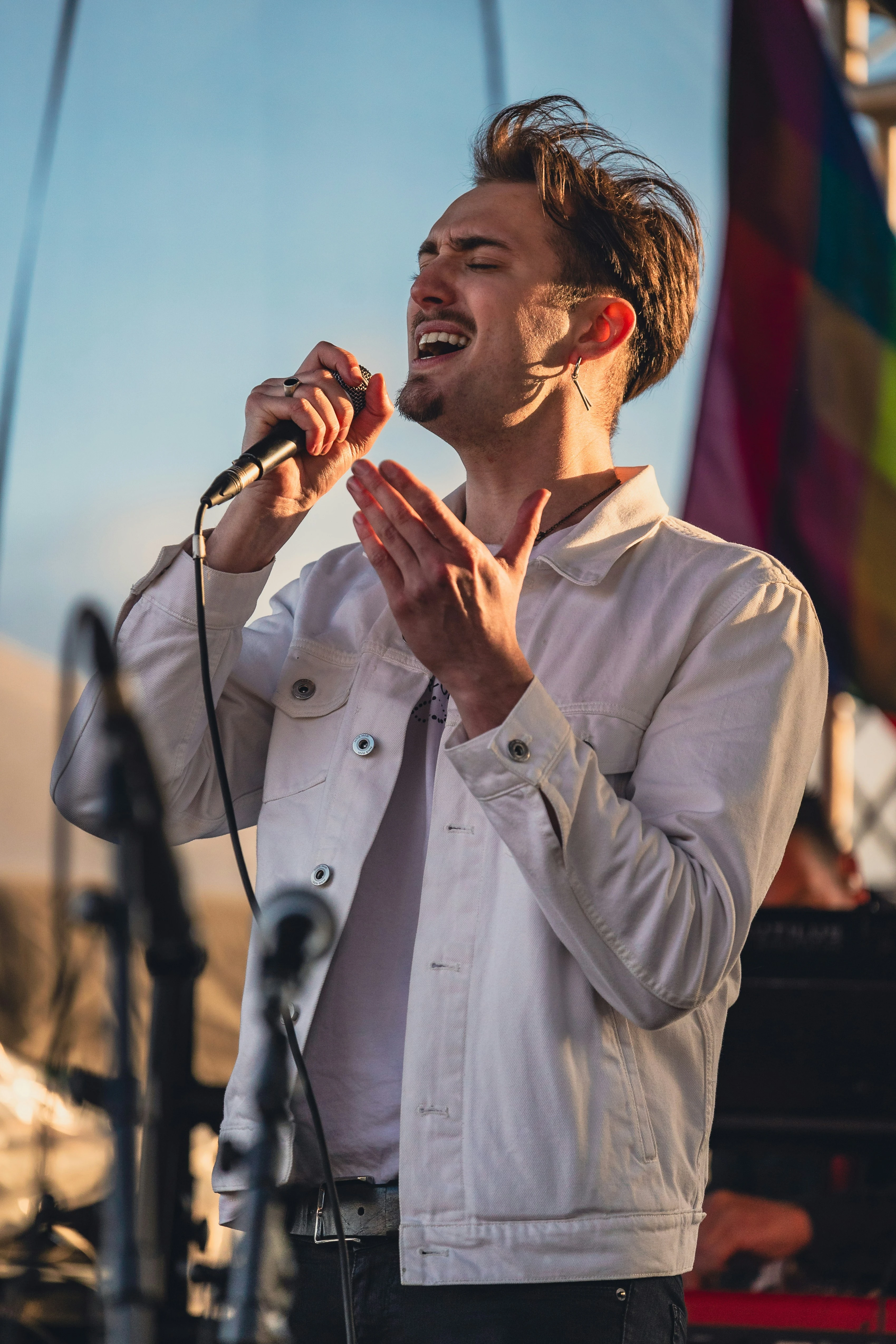 Singer in a blazer performs live with microphone at yacht party
